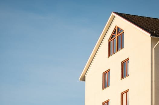 Minimalist modern residential building facade against clear blue sky.